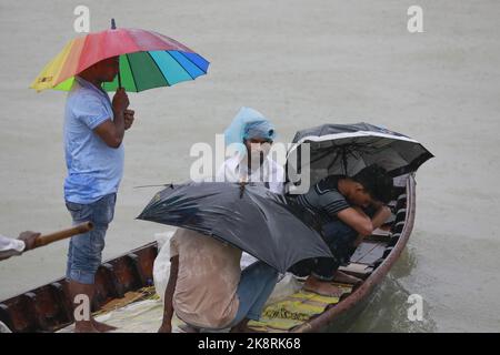 Dhaka, Bangladesh. 24th Ott 2022. I passeggeri del Bangladesh attraversano il fiume Buriganga mentre detengono ombrelli durante una forte pioggia e condizioni difficili causate dal ciclone Sitrang a Dhaka, Bangladesh, 24 ottobre 2022. Secondo la Bangladesh Inland Water Transport Authority (BIWTA) e il Dipartimento di Meteorologia del Bangladesh, il trasporto di acque interne è stato sospeso in quanto il ciclone Sitrang si avvicina dovrebbe attraversare la parte sud-sud-ovest del distretto di Barishal e Chattogram entro il 25 ottobre. Il Bangladesh Met Office ha avvertito che la tempesta ciclonica potrebbe intensificarsi ulteriormente e trasformarsi in un grave ciclone Foto Stock