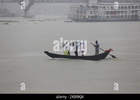 Dhaka, Bangladesh. 24th Ott 2022. I passeggeri del Bangladesh attraversano il fiume Buriganga mentre detengono ombrelli durante una forte pioggia e condizioni difficili causate dal ciclone Sitrang a Dhaka, Bangladesh, 24 ottobre 2022. Secondo la Bangladesh Inland Water Transport Authority (BIWTA) e il Dipartimento di Meteorologia del Bangladesh, il trasporto di acque interne è stato sospeso in quanto il ciclone Sitrang si avvicina dovrebbe attraversare la parte sud-sud-ovest del distretto di Barishal e Chattogram entro il 25 ottobre. Il Bangladesh Met Office ha avvertito che la tempesta ciclonica potrebbe intensificarsi ulteriormente e trasformarsi in un grave ciclone Foto Stock