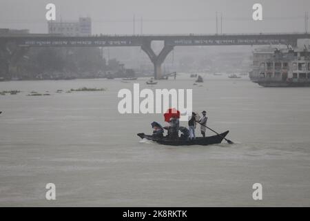 Dhaka, Bangladesh. 24th Ott 2022. I passeggeri del Bangladesh attraversano il fiume Buriganga mentre detengono ombrelli durante una forte pioggia e condizioni difficili causate dal ciclone Sitrang a Dhaka, Bangladesh, 24 ottobre 2022. Secondo la Bangladesh Inland Water Transport Authority (BIWTA) e il Dipartimento di Meteorologia del Bangladesh, il trasporto di acque interne è stato sospeso in quanto il ciclone Sitrang si avvicina dovrebbe attraversare la parte sud-sud-ovest del distretto di Barishal e Chattogram entro il 25 ottobre. Il Bangladesh Met Office ha avvertito che la tempesta ciclonica potrebbe intensificarsi ulteriormente e trasformarsi in un grave ciclone Foto Stock