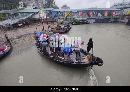 Dhaka, Bangladesh. 24th Ott 2022. I passeggeri del Bangladesh attraversano il fiume Buriganga mentre detengono ombrelli durante una forte pioggia e condizioni difficili causate dal ciclone Sitrang a Dhaka, Bangladesh, 24 ottobre 2022. Secondo la Bangladesh Inland Water Transport Authority (BIWTA) e il Dipartimento di Meteorologia del Bangladesh, il trasporto di acque interne è stato sospeso in quanto il ciclone Sitrang si avvicina dovrebbe attraversare la parte sud-sud-ovest del distretto di Barishal e Chattogram entro il 25 ottobre. Il Bangladesh Met Office ha avvertito che la tempesta ciclonica potrebbe intensificarsi ulteriormente e trasformarsi in un grave ciclone Foto Stock