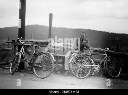 Norvegia, estate 1943 vita quotidiana durante la guerra. I permessi di viaggio erano difficili da raggiungere durante la seconda guerra mondiale, motivo per cui molti hanno scelto una bicicletta. Una giovane coppia ha affrontato il tratto Oslo / Ålesund. Qui fanno un respiro. L'uomo fuma una pipa. Foto: NTB Foto Stock