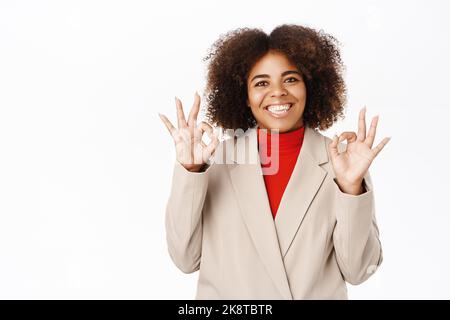 Persone aziendali. Felice afroamericano businesswoman lode smth eccellente, dà complimento, feedback positivo, si trova su sfondo bianco Foto Stock