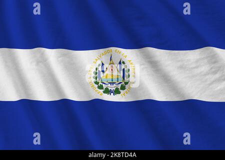 El Salvador bandiera con grandi pieghe ondeggianti da vicino sotto la luce studio interni. I simboli e i colori ufficiali in tessuto banner Foto Stock