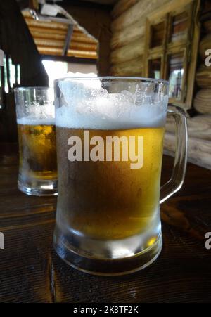 Bicchieri completi di birra leggera sul tavolo di legno presso il pub country birreria Foto Stock