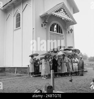 Søgne Agosto 22, 1959. Grande stand a Søgne quando la figlia del pescivendolo, Anne Marie Rasmussen, sposa il miliardario erede Steven C. Rockefeller. Ecco un gruppo di spettatori davanti alla chiesa, in attesa sotto la pioggia sotto gli ombrelloni. Foto: NTB / NTB Foto Stock