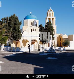 La Chiesa di San Giorgio aka Perivolas, Oia, Egeo isola di Santorini. Maschio in sagome nel cortile con ombre e alberi. Foto Stock