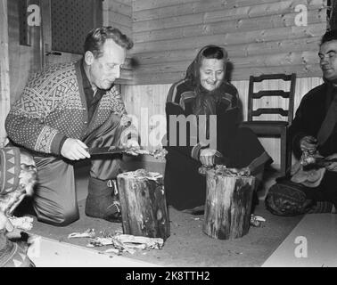 Border Jakobselv, Finmark Dicembre 1962. Il Ministro della Difesa Gudmund Harlem confina con Jakobselv con regali di Natale per i ragazzi che parlano del confine con l'Unione Sovietica. Il viaggio durò 5 giorni e divenne un viaggio duro in aereo, auto, barca e pulk. Qui da Neiden Fjellstue dove c'era concorrenza nel dividere i margini tra il ministro della Difesa (t.v.), Katri Jefrimoff ed Elias Pofanoff. Harlem ha vinto il trucco, grazie alle vecchie arti mediche e un nuovo coltello Finnmark. Foto: Ivar corrente di Aaserud / NTB Foto Stock