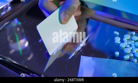 Sniffing di cocaina. Concetto di tossicodipendenza: Droghe pesanti preparate per il consumo. Cocaina, anfetamina, metica, metanfetamina. Vassoio in argento con farmaci in polvere Foto Stock