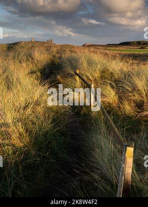 Castello di Dunstanburgh al tramonto. Embleton Bay, Alnwick, Northumberland, Regno Unito. 26 settembre 2022. Fotografia di Richard Holmes. Foto Stock