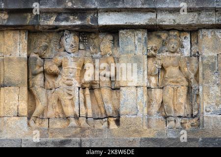 Indonesia, Java, Borobudur. Il più grande monumento buddista del mondo, circa 780-840 d.C. Patrimonio dell'umanità dell'UNESCO. Particolare di figure in pietra scolpita. Foto Stock
