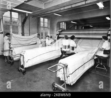 Oslo 19600106: Nel 1960, NSB aveva 3212 letti nei loro vagoni letto, e divennero sempre più popolari. Ogni giorno, un esercito di pulitori si trasferì nella zona di NSB a Lodalen, per lavare, pulire e cambiare biancheria da letto. La biancheria da letto viene lavata alla lavanderia di NSB a Lodalen, che nel 1959 ha gestito 1,5 milioni di chili di vestiti solo dalle auto da letto. Ciò corrisponde a circa 300.000 spostamenti del letto in un anno. Intorno a Natale ci sono spesso 3000 fogli al giorno! Foto: Ivar Aaserud / corrente / NTB Foto Stock