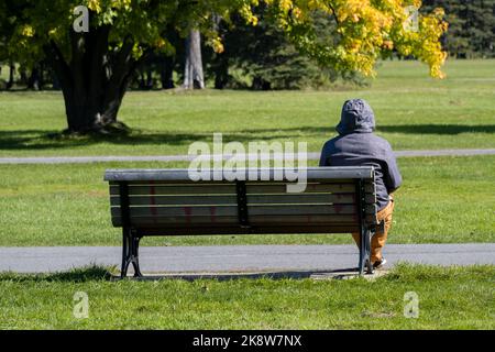 Montreal, Canada - 10 ottobre 2022: Uomo seduto su panchina nel parco Maisonneuve Foto Stock