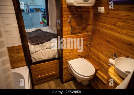 Interno bagno camper con wc, lavabo e pareti in legno. Foto Stock