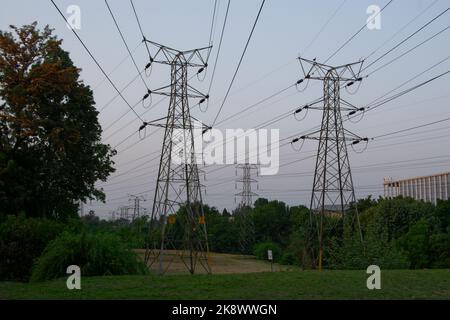 Power Pylon in un ambiente urbano con cavi sospesi direttamente sopra la testa. Foto Stock