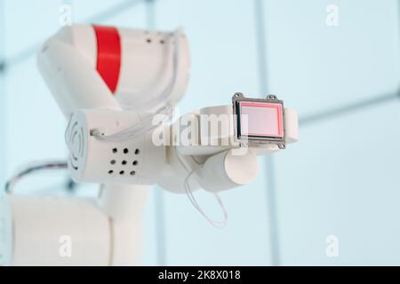 Braccio del robot con sensore di immagine a matrice CCD e CMOS nel manipolatore. Concetto sul tema della visione artificiale e del riconoscimento del modello Foto Stock