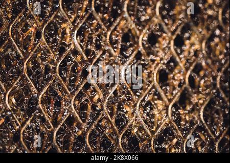 Macro di messa a fuoco selettiva di un filtro sporco cappa gamma cucina intasato di grasso. Foto Stock