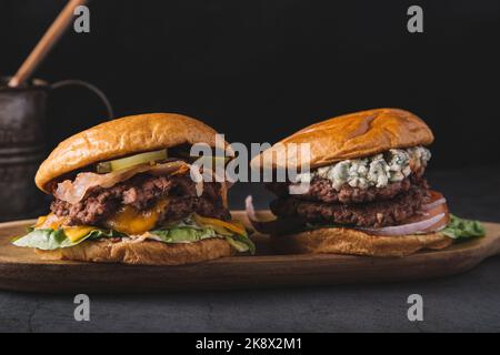 primo piano di hamburger doppi su un asse di legno Foto Stock