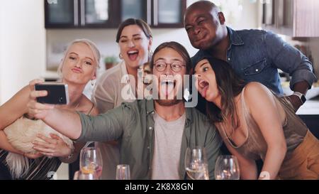 Chi vuole dessert noi facciamo. Un gruppo di giovani amici che prendono selfie durante un raduno a casa. Foto Stock