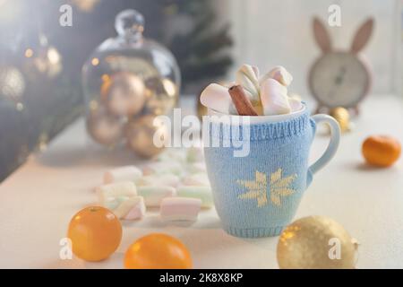 tazza da tè blu con caramelle al marshmello e decorazioni natalizie. Sfondo invernale - tempo a casa accogliente Foto Stock