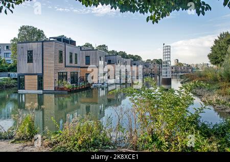 Rotterdam, Paesi Bassi, 12 ottobre 2022: Fila di ville galleggianti con facciate in legno in un vecchio bacino portuale nel quartiere di Feijenoord Foto Stock