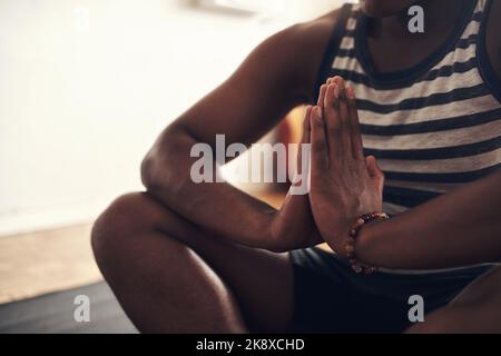 Essere in pace è un sentimento così illuminante. Primo piano di un uomo irriconoscibile che medita a casa. Foto Stock