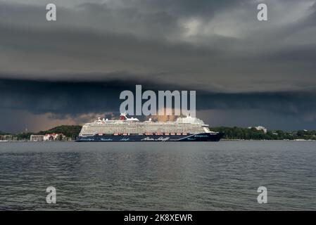 Kiel, Deutschland, Juli 2019 Dunkle Wolken über der Kieler Innenförde. Ein Gewitter mit Wolkenbruch kündigt sich an während das Kreuzfahrtschiff Mein Foto Stock