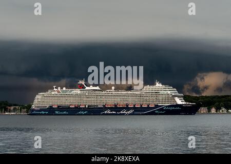 Kiel, Deutschland, Juli 2019 Dunkle Wolken über der Kieler Innenförde. Ein Gewitter mit Wolkenbruch kündigt sich an während das Kreuzfahrtschiff Mein Foto Stock