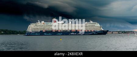 Kiel, Deutschland, Juli 2019 Dunkle Wolken über der Kieler Innenförde. Ein Gewitter mit Wolkenbruch kündigt sich an während das Kreuzfahrtschiff Mein Foto Stock