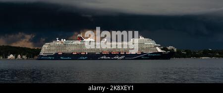 Kiel, Deutschland, Juli 2019 Dunkle Wolken über der Kieler Innenförde. Ein Gewitter mit Wolkenbruch kündigt sich an während das Kreuzfahrtschiff Mein Foto Stock