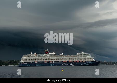 Kiel, Deutschland, Juli 2019 Dunkle Wolken über der Kieler Innenförde. Ein Gewitter mit Wolkenbruch kündigt sich an während das Kreuzfahrtschiff Mein Foto Stock