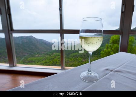 Mano di un uomo che mette un ghiaccio in un vino bianco su un tavolo in un ristorante. Foto Stock