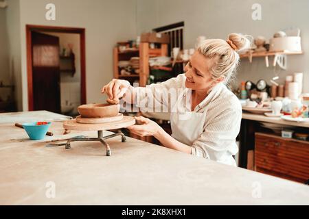 Adoro la ceramica e tutto ciò che la riguarda. Una donna che forma una pentola di argilla nel suo laboratorio. Foto Stock