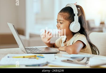 Videochiamata, formazione online e bambino con laptop, cuffie e tavolo da casa per una lezione virtuale di e learning. Ciao, zoom chiamata e ragazza bambino in elearning Foto Stock