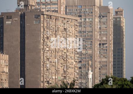 Una fila di alti blocchi di appartamenti, tutti con balconi, aria condizionata e piatti TV, sulla riva del Nilo Foto Stock