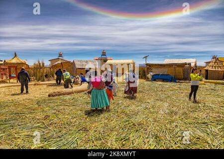 Puno, Perù - 21 settembre 2022: Su un'isola galleggiante di paglia Uros sul lago Titicaca con alone di sole nel cielo. Foto Stock