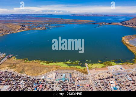 Veduta aerea del Lago Titicaca in Perù con la città di Puno e il suo porto in primo piano. Foto Stock