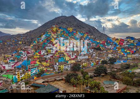 Shanty città di Lima, Perù. Le case un tempo grigie del quartiere impoverito della capitale peruviana Lima brillano in tutti i colori. La campagna mira a. Foto Stock