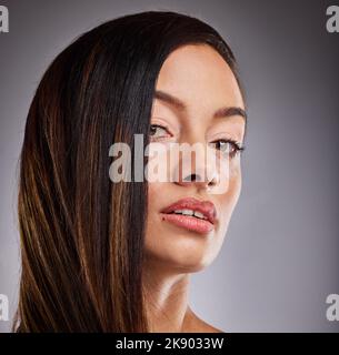 Bellezza e vitiligine donna con cosmetici sul viso su sfondo studio. Ritratto di un modello giovane, pigmentato e cosmetico con viso Foto Stock