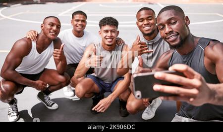 Selfie, basket e sport con una squadra in campo che scatta una fotografia dopo una partita o un allenamento insieme. Telefono, collaborazione e fitness con un Foto Stock
