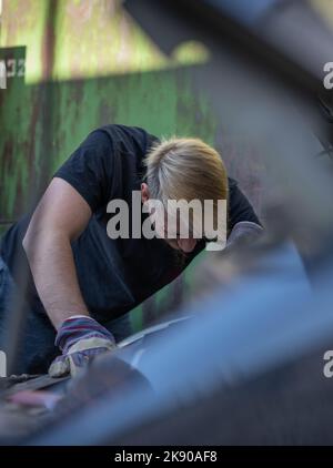 Il meccanico ripara la vettura sotto il cofano Foto Stock