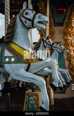 Un primo piano verticale di cavalli in un giro in giostra allegro Foto Stock