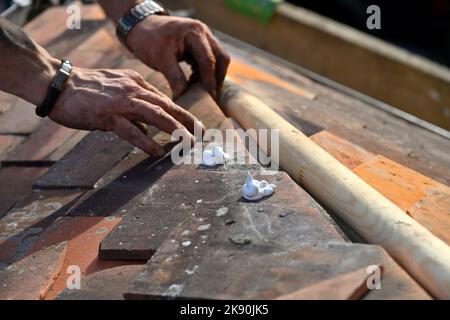 Lavori di copertura su tegole di argilla residenziale hipped Bay tetto, montaggio angolo taglio tegole di argilla alla caraffa Foto Stock
