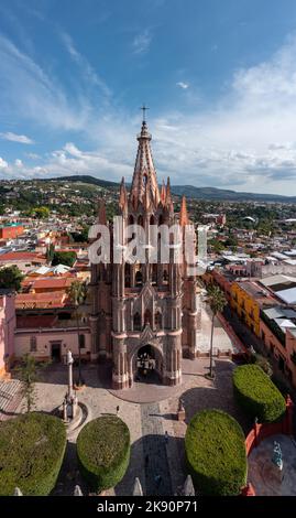 Una foto verticale della Chiesa di San Michele (Parroquia de San Miguel Arcangel) in Messico contro un cielo blu con la città sullo sfondo Foto Stock