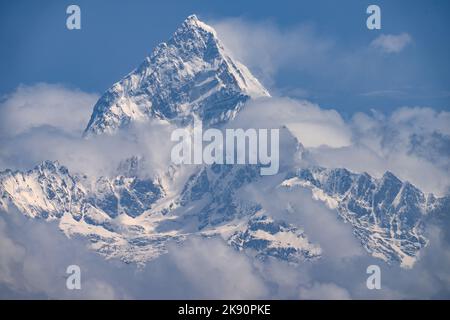 Il Machapuchare AKA Fishtail montagna nevoso picco nelle nuvole, Himalaya Range, Nepal. Foto Stock