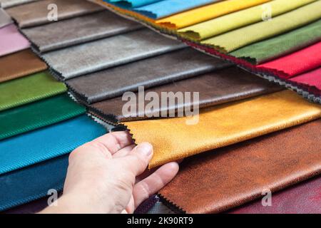 Donna mano sceglie campioni di tessuto colorato sul tavolo primo piano Foto Stock