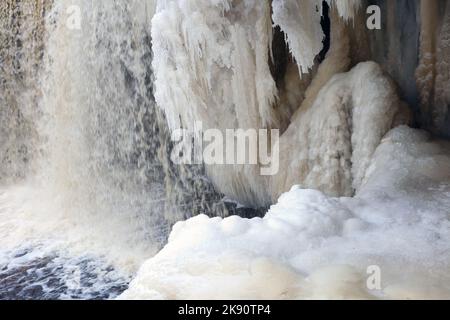 blocchi di ghiaccio sulla cascata e sui ghiaccioli. enorme flusso di acqua ghiacciata di ghiaccio pende su una roccia, neve d'inverno Foto Stock