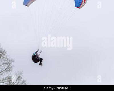 Skydiving sport estremi - paracadutista con paracadute dispiegato. Lo sportivo che vola su un parapendio. Bellissimo parapendio in volo su un dorso leggero Foto Stock