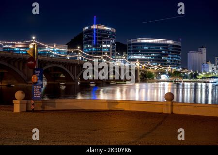 Un'inquadratura dal basso del lago Tempe Town e degli edifici e ponti vicini di notte, Arizona Foto Stock