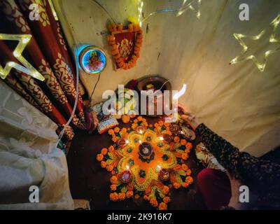 Kathmandu, Bagmati, Nepal. 25th Ott 2022. Una donna offre preghiere alla dea Laxmi, dea indù della ricchezza dopo aver preparato Rangoli colorati in celebrazione di Tihar o Diwali, il festival delle luci a Kathmandu, Nepal il 25 ottobre 2022. Tihar, la festa indù dei fiori e delle luci è celebrata per cinque giorni. (Credit Image: © Sunil Sharma/ZUMA Press Wire) Foto Stock