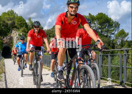 Un gruppo di ciclisti norvegesi di mezza età che attraversano un ponte sulla ferrovia da Spoleto a Norcia in disuso a noleggio. Umbria, Italia. Foto Stock